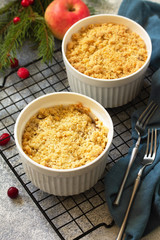Homemade winter dessert. Apple crumbles with cranberries on a stone or slate countertop background.