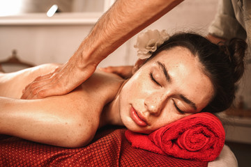 Fototapeta na wymiar Alternative Medicine. Therapist healing woman smiling relaxed doing back massage close-up