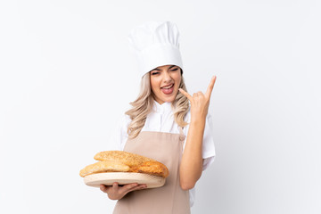 Teenager girl in chef uniform. Female baker holding a table with several breads over isolated white background unhappy and frustrated with something