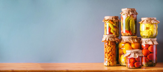 Сucumber, squash and tomatoes pickling and canning into glass jars. Ingredients for vegetables preserving. Healthy fermented food concept. Harvest storing