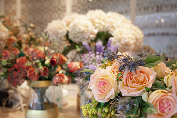 Fake pink rose and other flower in room.
