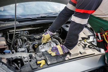 Hands of mechanic's in protective gloves with car engine close up