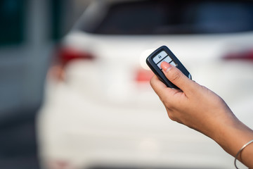 Woman hand pushing button on remote control car key