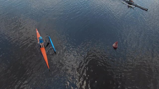 Canoeing competition-rowing boating sport. Athletes girls rowers on outrigger canoe boats with stabilizer in the river water area. Aerial survey