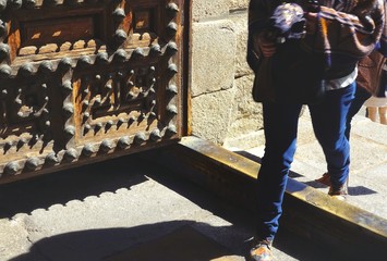 Unknown woman crosses the threshold of the Iglesia de San Ildefonso church in Toledo, Spain 