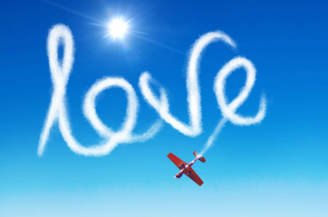 Inscription in the sky - love left by white smoke from an airplane.