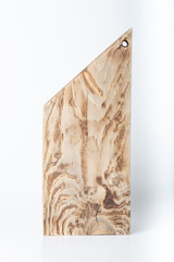 Handmade burned cutting board on a light background. Rough weathered wooden board
