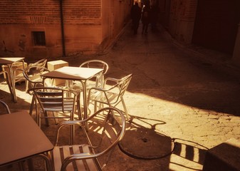 Tables and chairs of street cafe in an ancient area Toledo. 