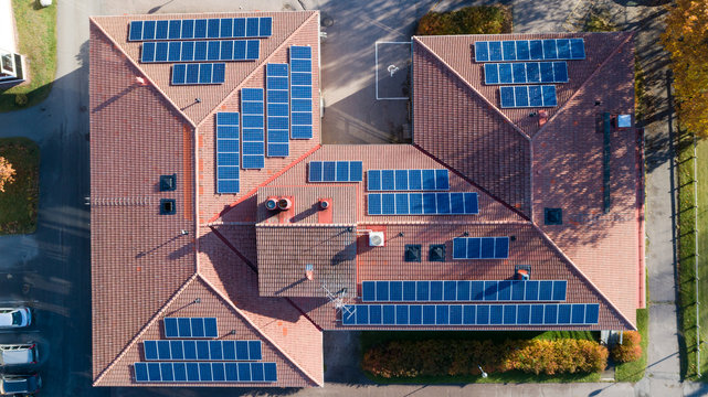 Aerial Top View Of New Modern Residential House Cottage With Blue Panels. Renewable Ecological Green Energy Production Concept.