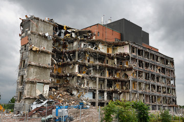Highrise apartment building in the process of being demolished under gloomy gray sky in St...