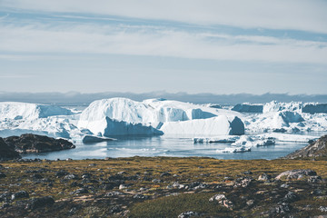 Fototapeta na wymiar View towards Icefjord in Ilulissat. Easy hiking route to the famous Kangia glacier near Ilulissat in Greenland. The Ilulissat Icefjord seen from the viewpoint. Ilulissat Icefjord was declared a UNESCO