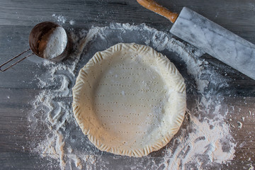 Preparing to make pastry dough pie shell on floured surface with rolling pin flat lay