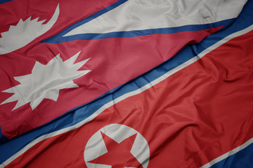 waving colorful flag of north korea and national flag of nepal.