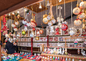 Naklejka premium Christmas tree decorations for sale in Berlin Christmas market. Stalls with crafts souvenirs, decorations and holiday attributes on the Bazaar.