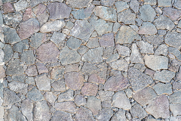 full-frame close-up of uneven dry stone wall background