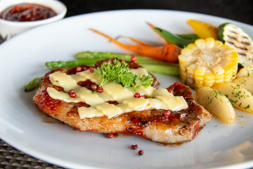  pork steak cheese on top in white plate