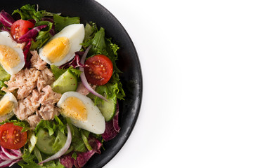 Salad with tuna, egg and vegetables isolated on white background. Top view. Copy space