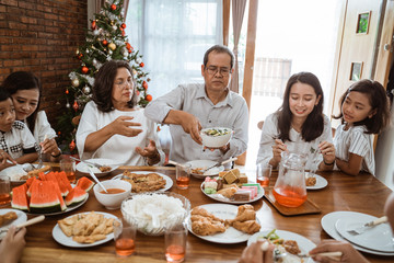 happy asian family tradition having lunch together on christmas day at home