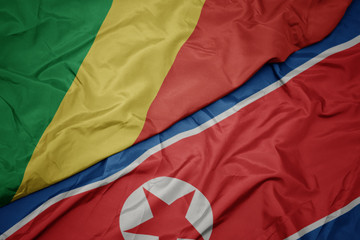 waving colorful flag of north korea and national flag of republic of the congo.