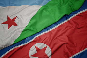 waving colorful flag of north korea and national flag of djibouti.