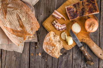 traditional fresh bread with slices od bacon with onion served on wooden plate, european national snack, slovak food 