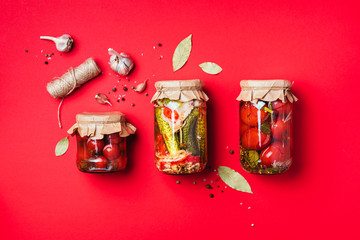 Сucumber, squash and tomatoes pickling and canning into glass jars. Ingredients for vegetables preserving. Healthy fermented food concept. Top view. Copy space.