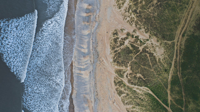 Aerial view of beautiful beach with green sanddunes near Ogmore-by-Sea, Wales.