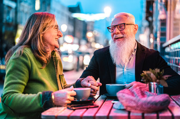 Hipster retired senior couple in love enjoying cappuccino at outdoor cafeteria - Joyful elderly...