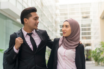 Malay Couple wearing suit walking at the office building