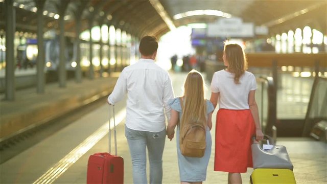 Young Family with Cute Daughter, Walking On Railway Platform Holding Suitcase. Best Trip and Vacations Concept. Caucasian Appearance.