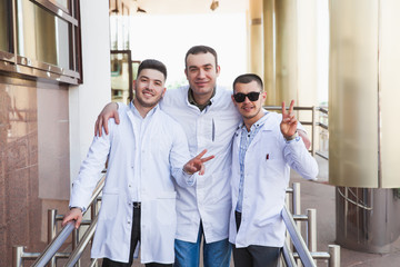 A group of European male medical students presented outdoor against the university door on the steps