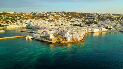 Fototapeta premium Aerial drone panoramic photo of picturesque old port in main village of Mykonos island at sunset and iconic church of Paraportiani with beautiful colours, Cyclades, Greece