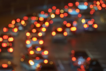 Defocused photography of urban night traffic. The lights of blurred motion at the highway.  The road is filled out cars.