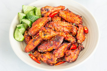 Cloce Up Baked Chicken Wings in a Bowl with Cucumber Cubes, Top View, Chicken Appetizer Photo..