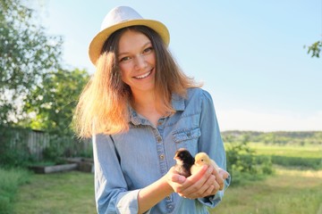Portrait of beautiful girl on farm with two newborn chicks in hand © Valerii Honcharuk