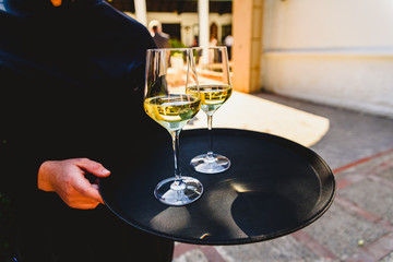 Tray with two glasses of champagne held by a waiter.