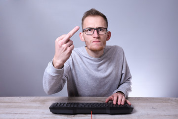 Funny nerd young businessman, man working on computer.Typing on the keyboard programmer in glasses...