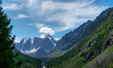 Obraz premium Landscape of snowy mountain peaks in the clouds. The concept of global warming and glacier melting.