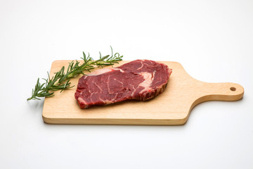 Raw seasoned beef slice on a wooden board