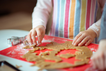 Closeup photo of children's hands making ginger cookies for Christmas