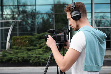 Video operator with camera working on city street. Space for text