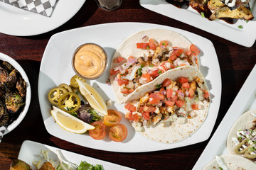 Fish tacos served on flour tortillas and topped with pico de galo. Sides of jalapenos, lime, and a spicy cream sauce.