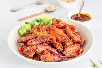Baked Chicken Wings with Cucumber Cubes, Hot Sauce and Sesame Seeds, Close Up Photo of Chicken Appetizer..