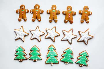 Handmade decorating of festive gingerbread cookies in the form of stars, snowflakes, people, socks, staff, mittens, Christmas trees, hearts for xmas and new year holiday. preparation for holidays