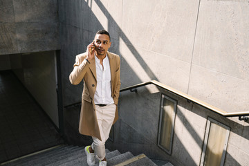 Portrait of businessman on the phone leaving underground station
