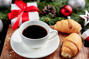 Christmas coffee and croissants with Christmas tree and gifts, toys on a stone background