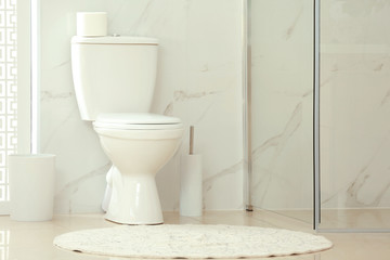 Naklejka na ściany i meble Modern toilet bowl with roll of paper in bathroom
