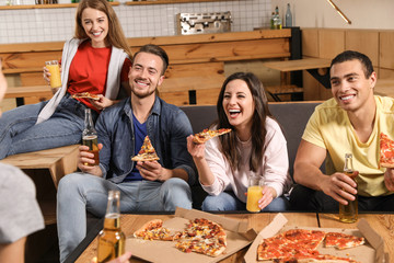 Group of friends having fun party with delicious pizza in cafe