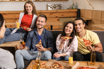 Group of friends having fun party with delicious pizza in cafe