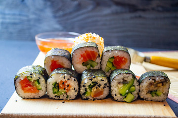 red fish sushi on a wooden tray